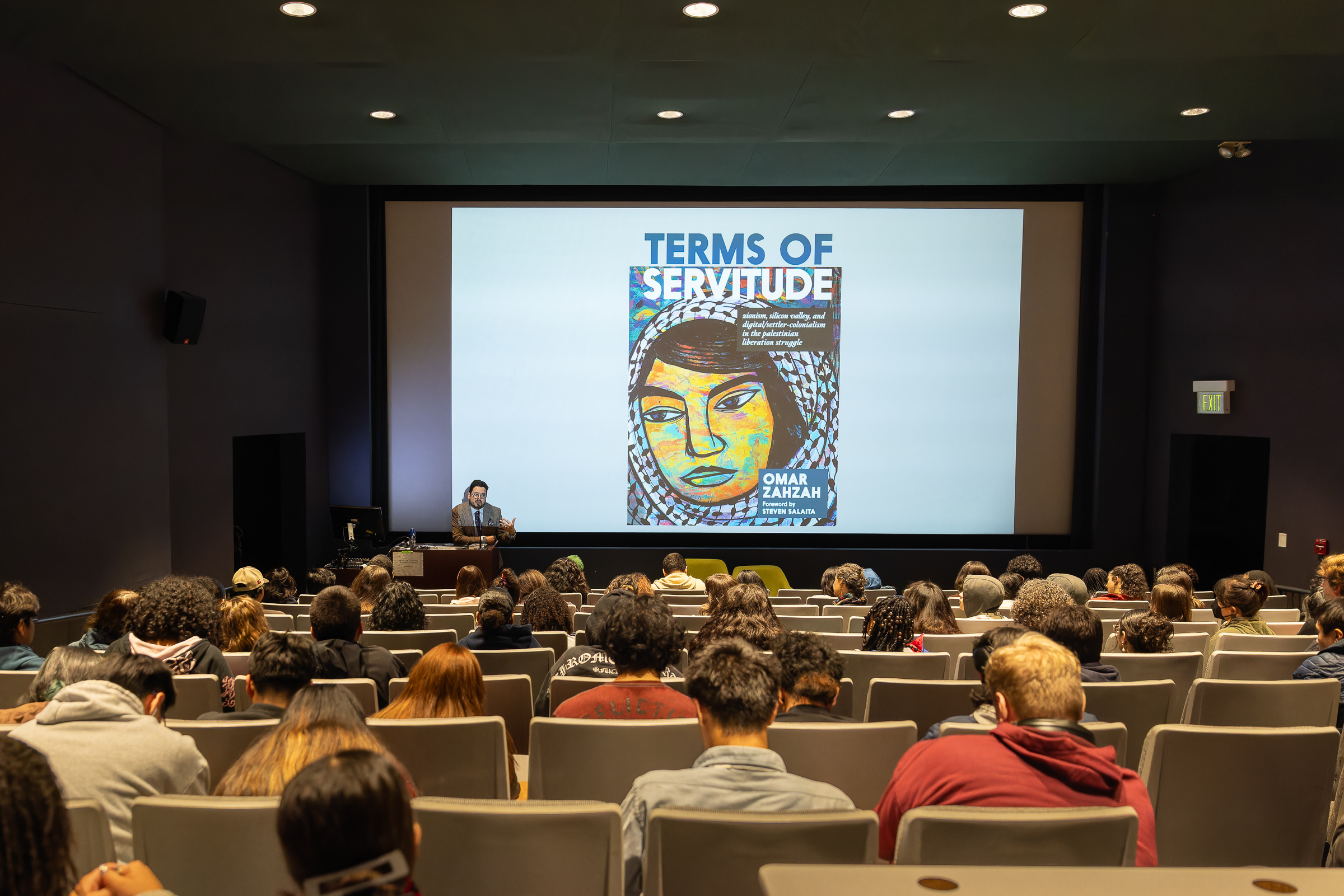 The book cover, "Terms of Servitude," being projected on the screen.