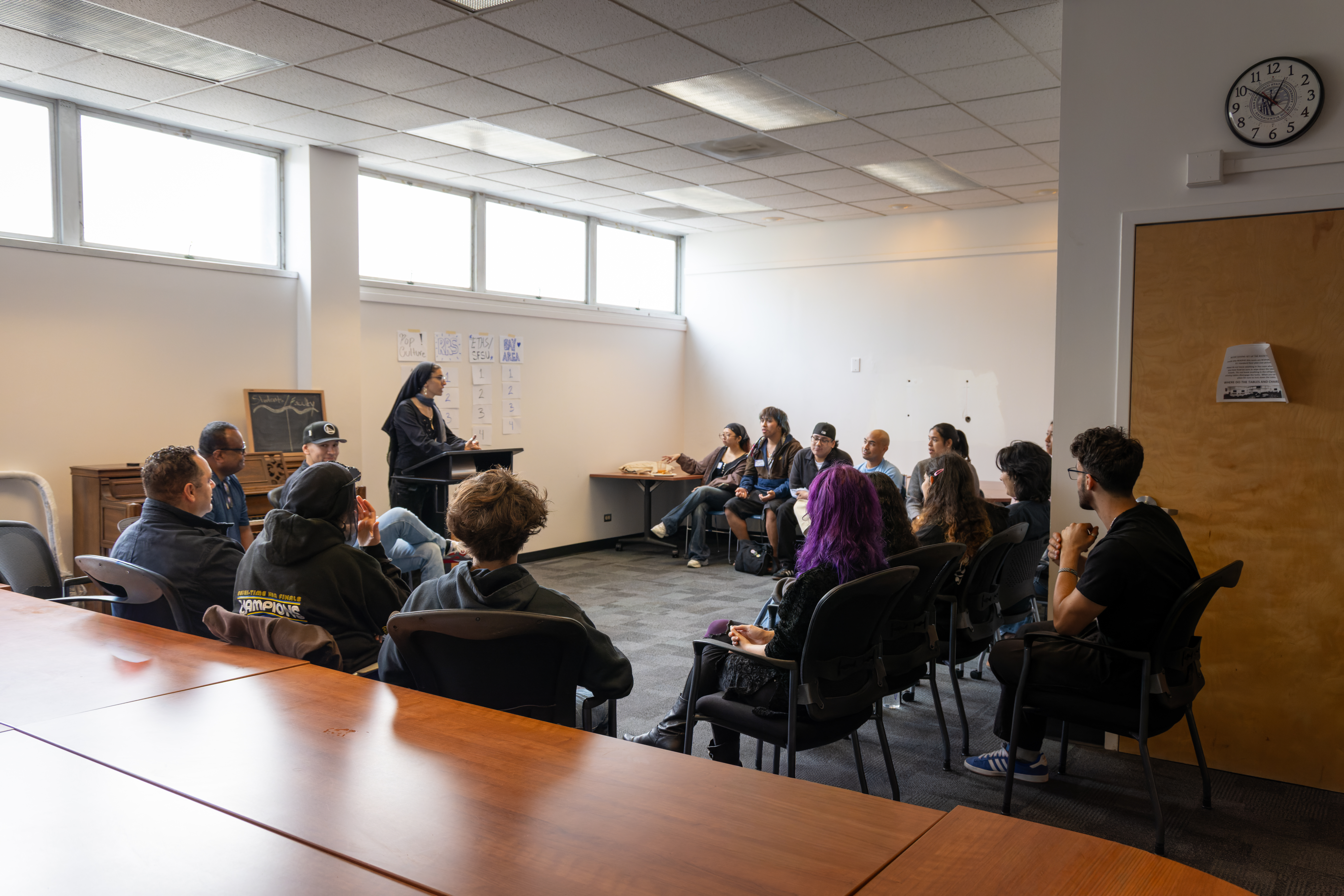 Wide shot of the entire room, with everyone sitting in a circle.