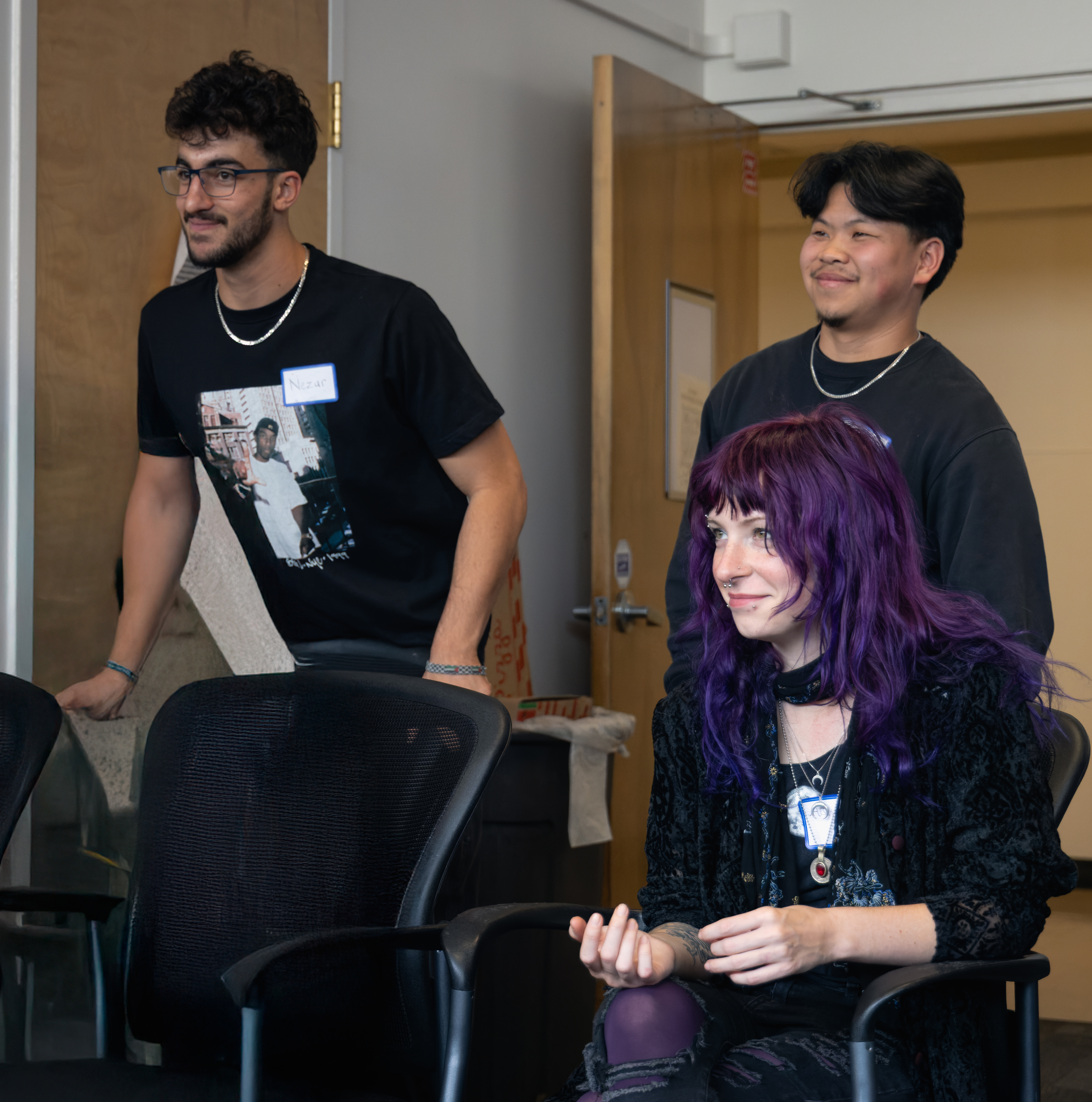 Three students looking at someone talking